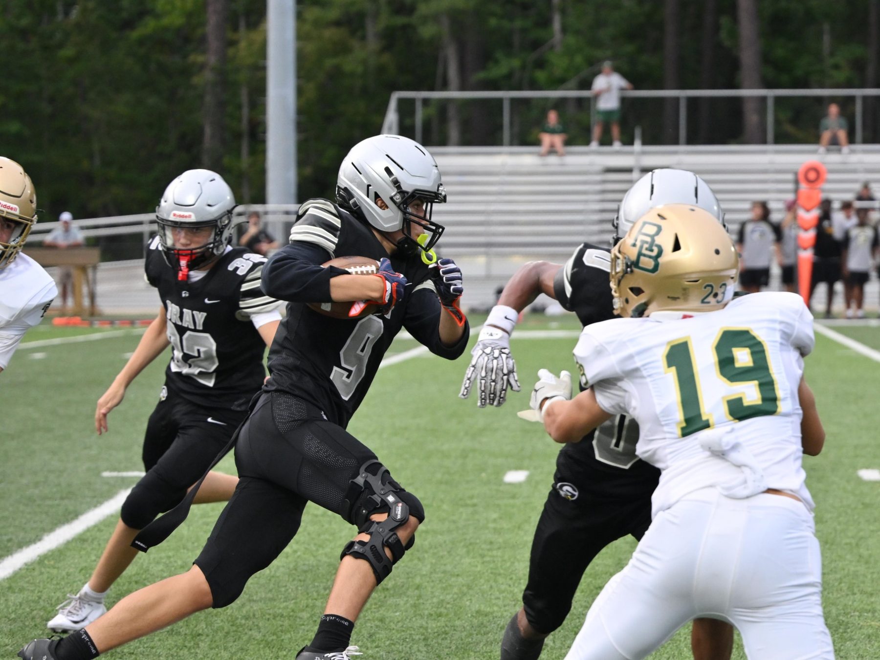 Luke Sevilla carrying the football in traffic for Gray Collegiate Academy
