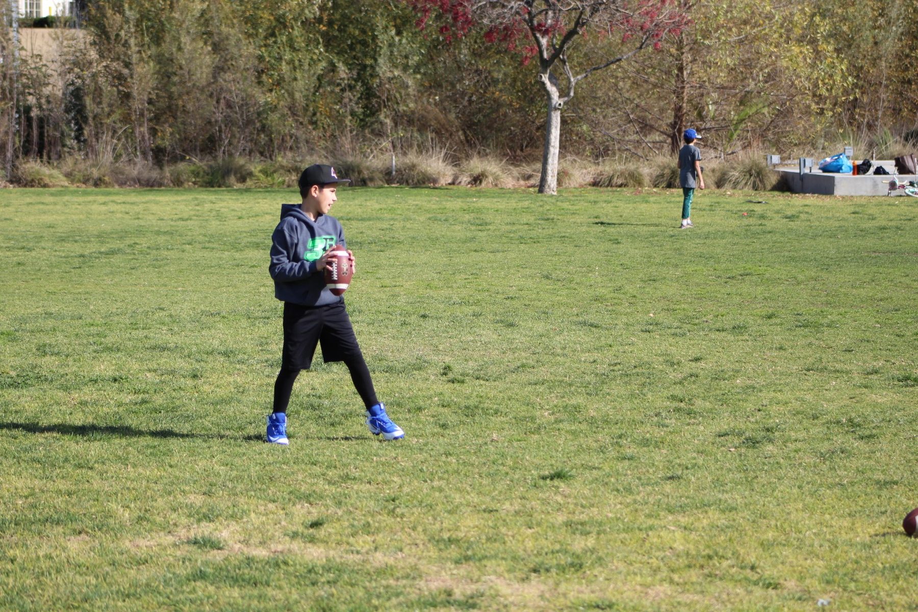 Luke Sevilla holding the football during youth quarterback work