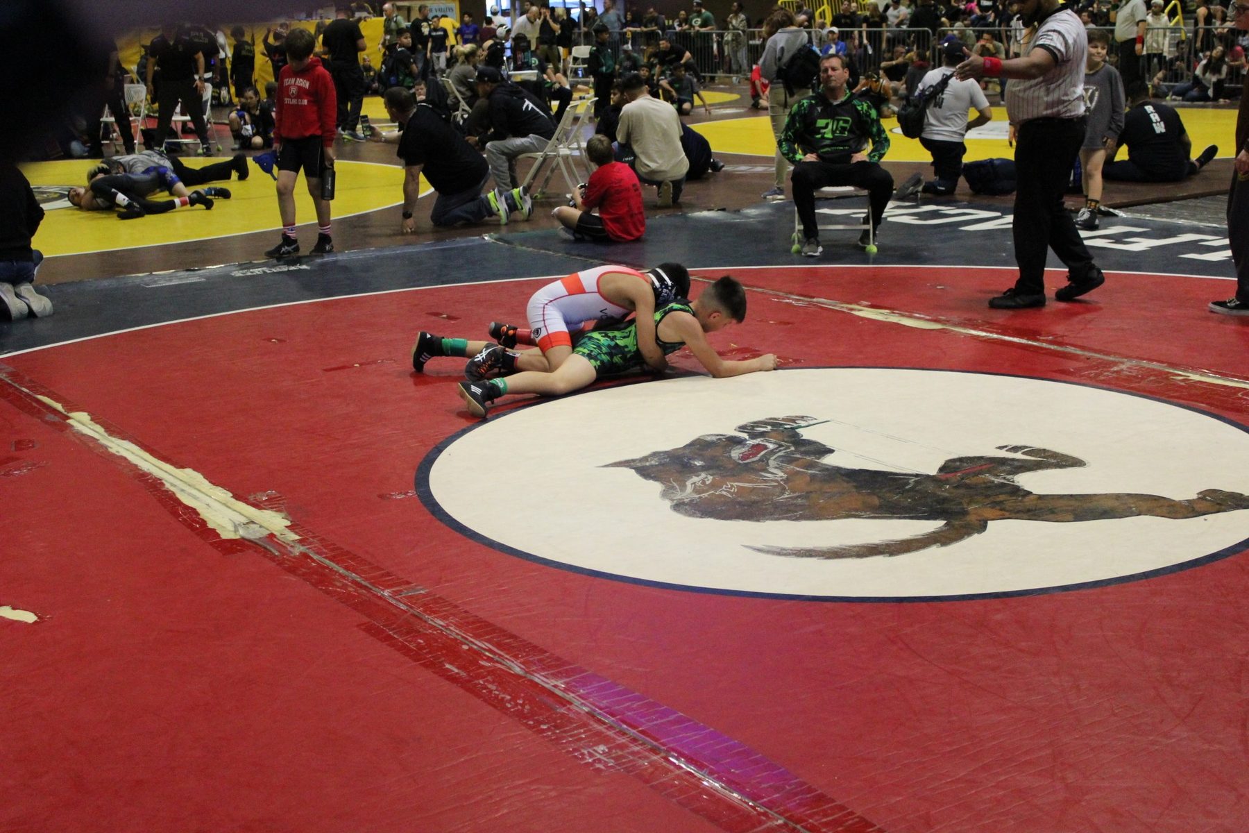Luke Sevilla wrestling from top position at a youth tournament